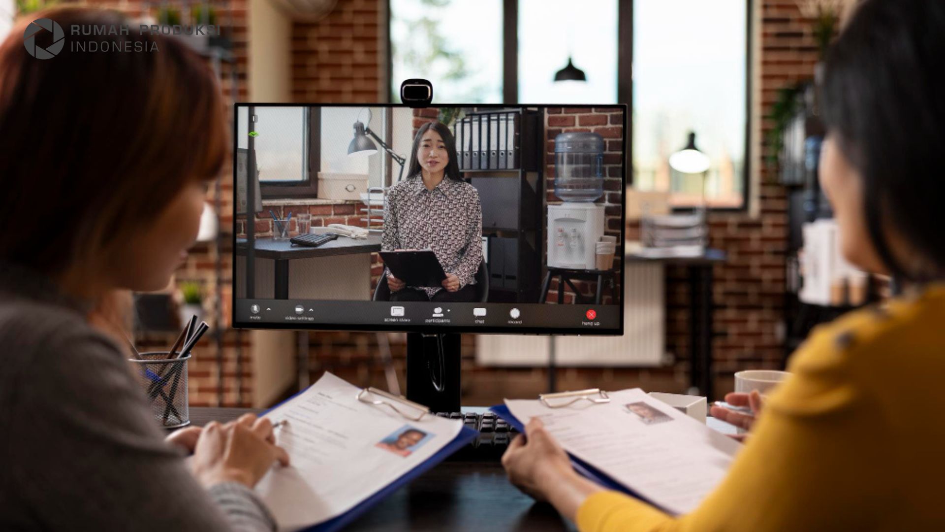 event hybrid dengan peserta offline dan online yang terhubung melalui layar besar.