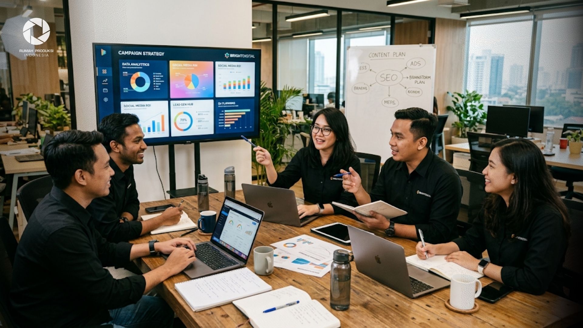 Tim digital marketing agency sedang mendiskusikan strategi pemasaran di meja kerja modern.